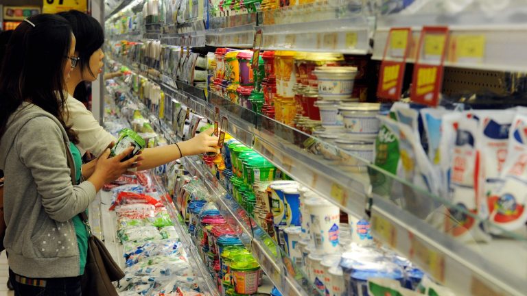 Asian ladies buying dairy products at a supermarket.