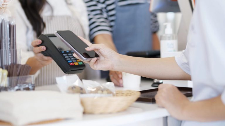 Female customer paying using mobile phone.